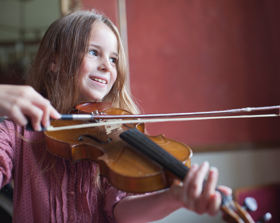 Young violinist smiling while playing